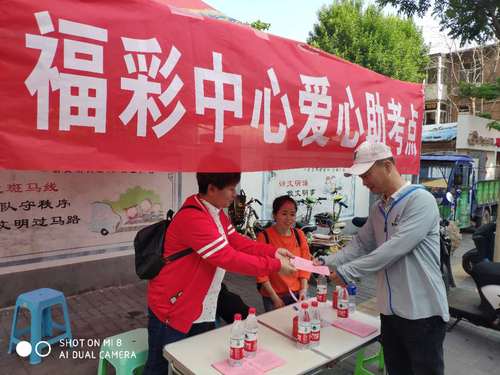 工作人员向考生家长发放《福彩助学明白纸》